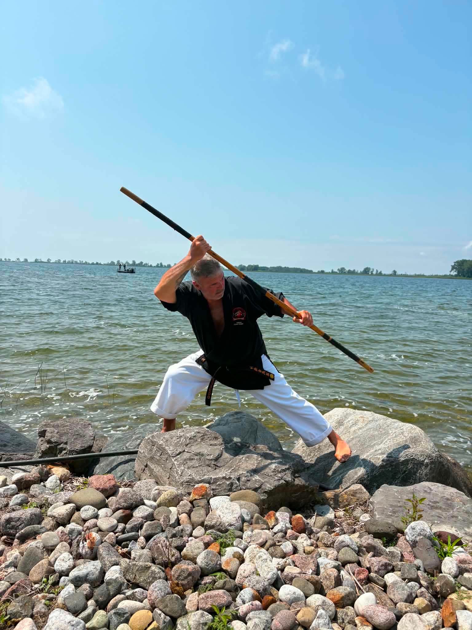 Praticien en garde au bo sur le rivage — entraînement kobudo
